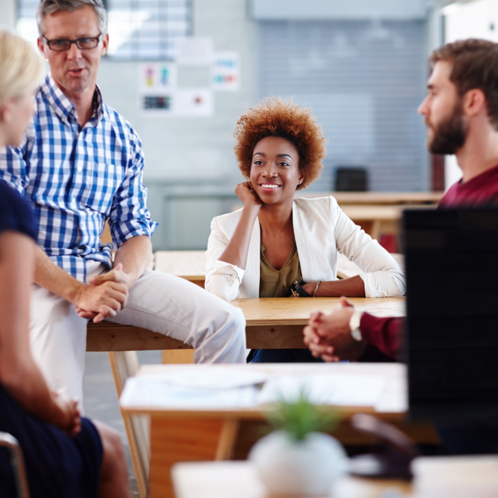 Conversa em equipe dentro de uma sala com varias mesas.